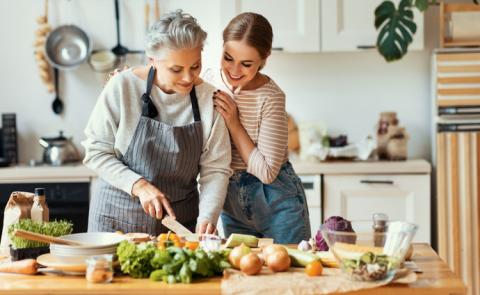 Mujer mayor con niña preparando comida saludable en la cocina