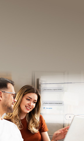 Dos personas sentadas revisando una información en un computador.