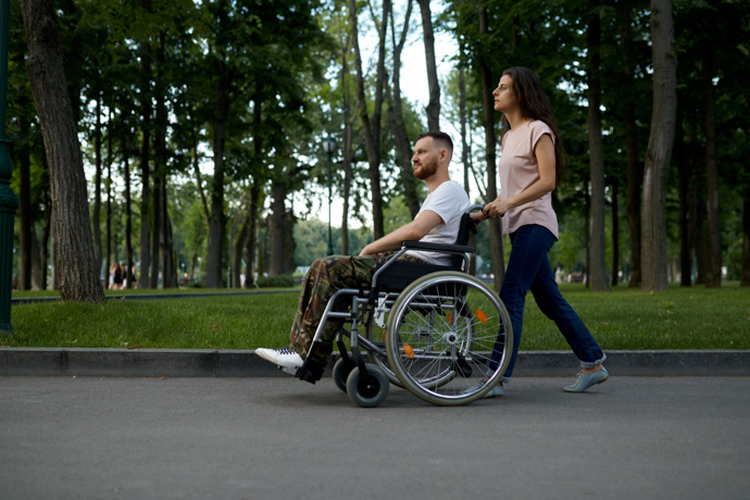 Pareja y chico en silla de ruedas al conocer los avances de la esclerosis múltiple.