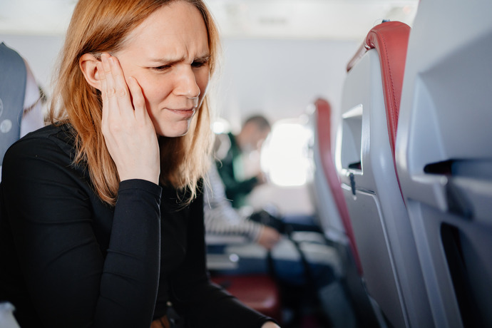 Imagen de cómo afecta el no destapar los oídos por el cambio de presión en un avión.
