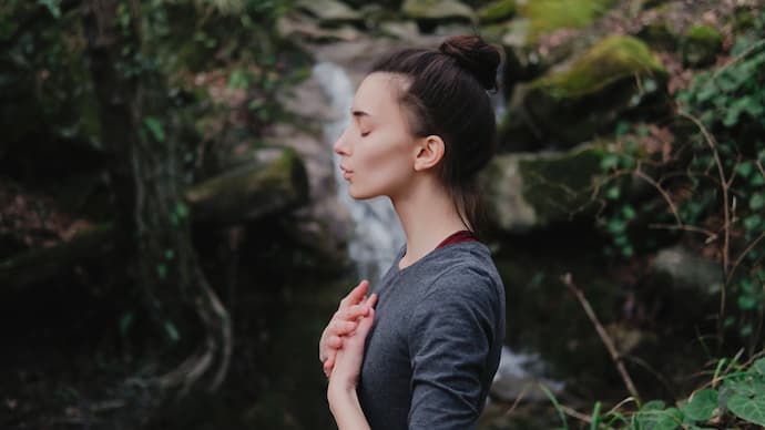 mujer practicando la respiración del león o simhasana