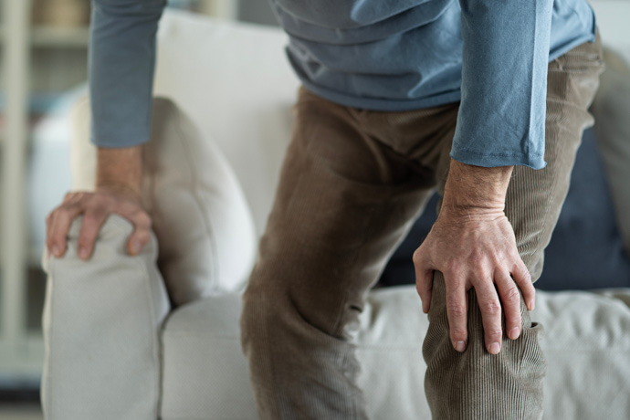 Hombre con artrosis sujetándose de la rodilla.