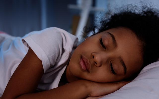 Niña durmiendo lo suficiente como hábito de vida saludable.