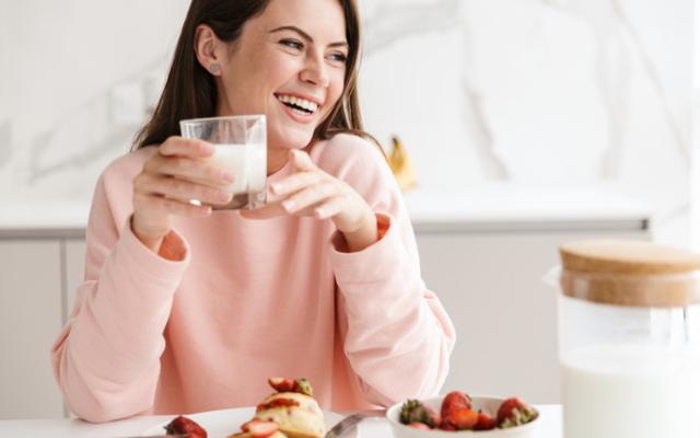 Mujer disfrutando de los beneficios de la leche para la salud.