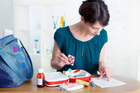 Mujer preparando un botiquín de viaje