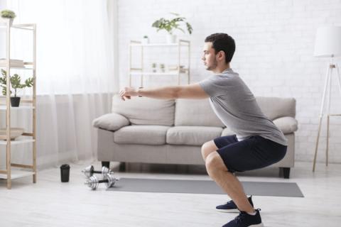 Hombre haciendo sentadillas en casa
